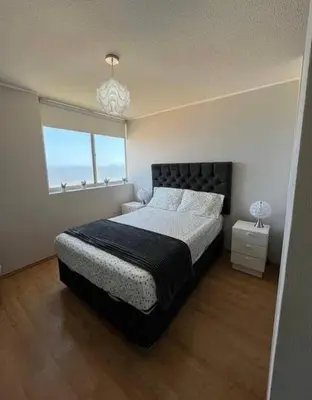 a bedroom with a large bed and a window at Departamento con balcon y vista al mar in Lima