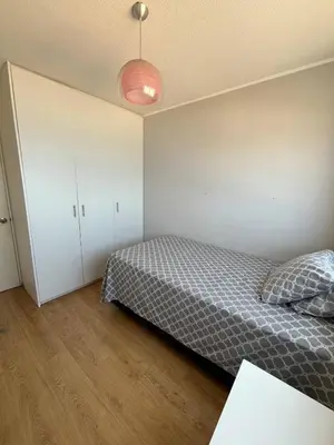 a bedroom with a bed and a white cabinet at Departamento con balcon y vista al mar in Lima