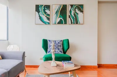 a living room with a green chair and a table at Appealing 1BR Beautiful View in Miraflores in Lima