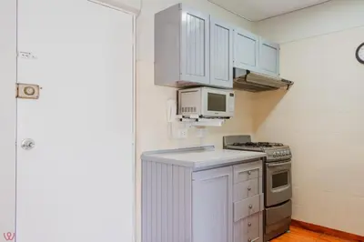 a kitchen with white cabinets and a stove and microwave at Appealing 1BR Beautiful View in Miraflores in Lima