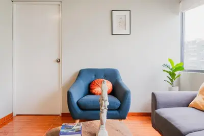 a blue chair sitting in a living room next to a couch at Appealing 1BR Beautiful View in Miraflores in Lima