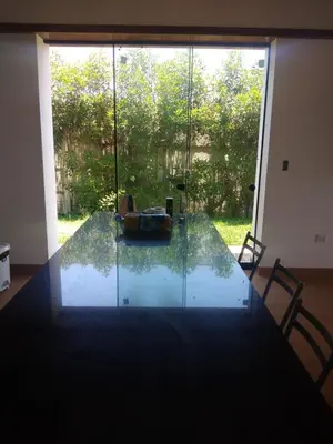 a glass table in a room with a large window at Condominio ecológico las gardenias de Asia