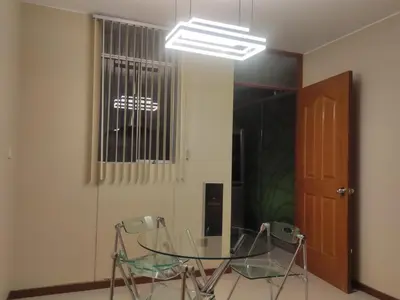 a dining room with two chairs and a glass table at Casa Oasis Meneses in Ica