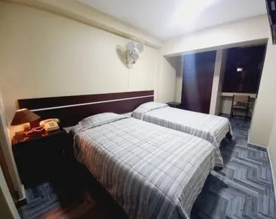 a hotel room with two beds and a telephone at Hotel Perú Pacífico in Lima