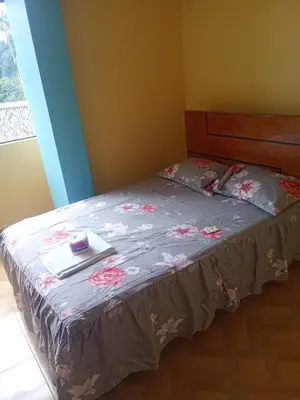 a bed with a book on top of it at Hotel Kashiri in Sabeti