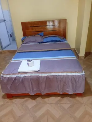 a bed with a wooden headboard and a plate on it at Hotel Kashiri in Sabeti
