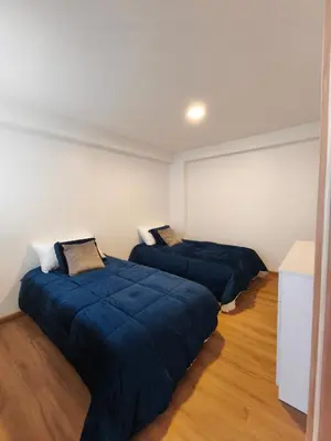 two beds in a room with blue blankets at La Casita De Colores Cusco in Cusco