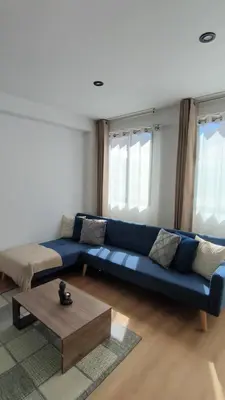 a living room with a blue couch and a coffee table at La Casita De Colores Cusco in Cusco