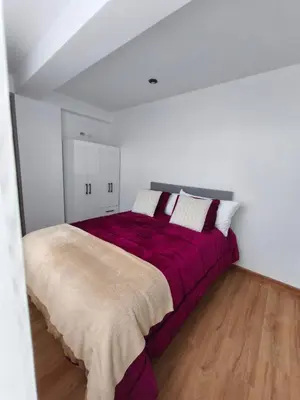 a bedroom with a large bed with a purple blanket at La Casita De Colores Cusco in Cusco