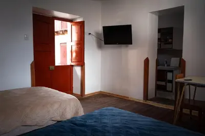a bedroom with a bed and a television on the wall at Mini apartment in downtown Cusco in Cusco