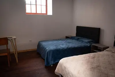 a bedroom with two beds and a window at Mini apartment in downtown Cusco in Cusco