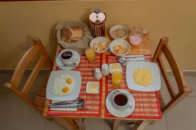 a table with breakfast foods and drinks on it at Kamma Guest House in Ollantaytambo