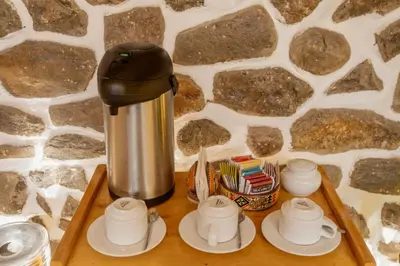 a coffee pot and cups on a wooden tray at Kamma Guest House in Ollantaytambo