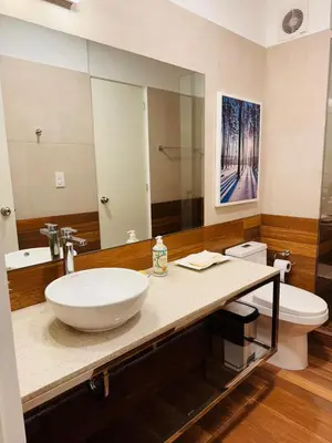 a bathroom with a sink and a toilet and a mirror at Monterrico Polo Aparts 19 - Dpto de Estreno con Balcon frente Embajada USA in Lima