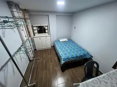 a small bedroom with a bed and a mirror at Alojamiento ideal Equipado in Huancayo