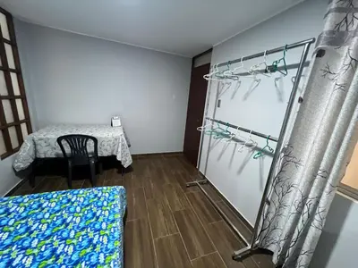 a room with a table and a chair and a room with a glass door at Alojamiento ideal Equipado in Huancayo