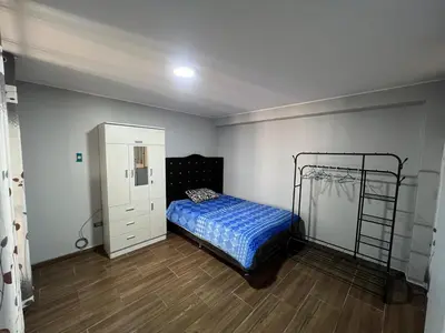 a bedroom with a bed and a dresser at Alojamiento ideal Equipado in Huancayo