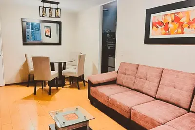 a living room with a couch and a table at Apartamento cómodo con piscina en el Centro Histórico, Lima in Lima