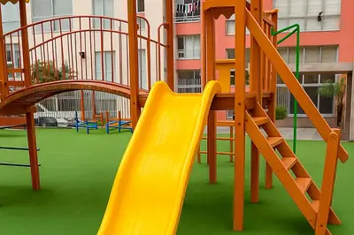 a playground with a yellow slide and a ladder at Apartamento cómodo con piscina en el Centro Histórico, Lima in Lima