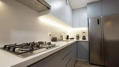 a kitchen with a stove and a stainless steel refrigerator at e-t*| Apartamento vista espectacular in Lima