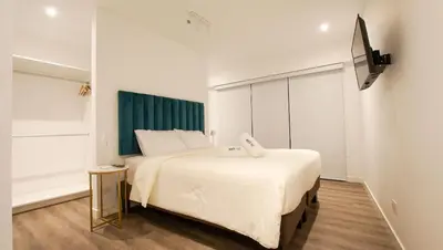 a hotel room with two beds and a television at e-t*| Apartamento vista espectacular in Lima