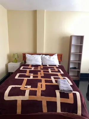 a bedroom with a bed with a blanket on it at Habitación a 15 min del Aeropuerto in Lima