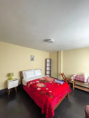 a bedroom with a bed with a red blanket at Habitación a 15 min del Aeropuerto in Lima
