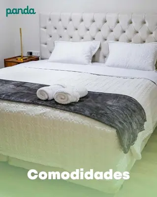 a bed with two rolled up towels on it at PANDA Hotel in Chancay
