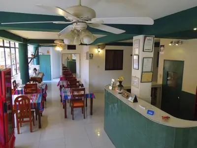 a restaurant with a ceiling fan and tables and chairs at Libon's Hotel in Nazca