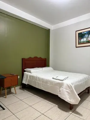 a bedroom with a large bed and a table at Libon's Hotel in Nazca