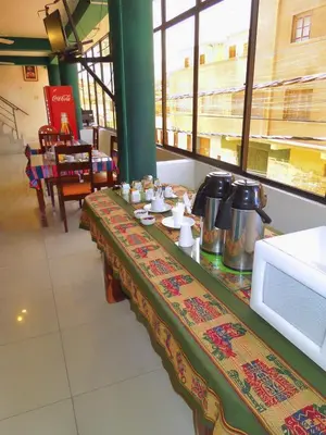 a long table in a restaurant with a counter top at Libon's Hotel in Nazca