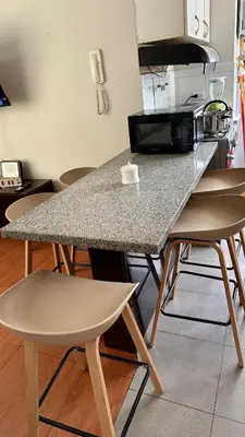 a kitchen with a table with chairs and a microwave at Hermoso Departamento Frente al Escuela de Oficiales de La policia in Lima