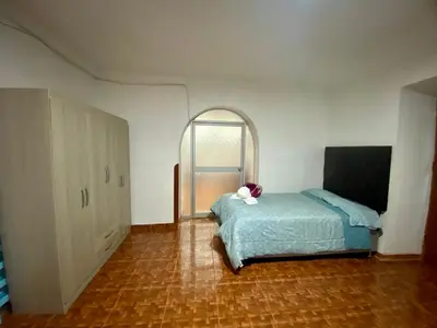 a bedroom with a bed and an arched window at Guadita House in Cusco