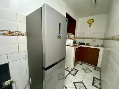 a small kitchen with a refrigerator and a microwave at Guadita House in Cusco