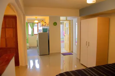 a living room with a refrigerator and a kitchen at Historical Center Apartments in Cusco