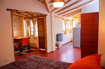 a living room with a bed and a kitchen with a table at Historical Center Apartments in Cusco