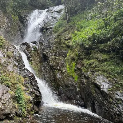 a waterfall on the side of a rocky mountain at Chunchu Wasi All included