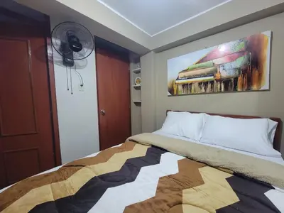 a bedroom with a bed with a painting on the wall at LUJO HOGAR - Cerca a Plaza Norte - UNI - Aeropuerto in Lima