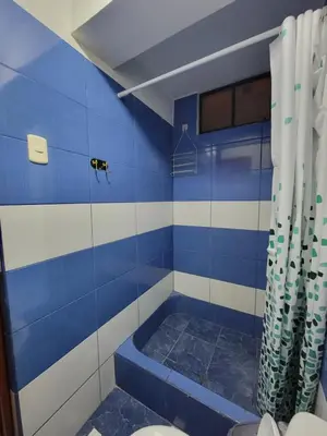 a blue and white bathroom with a toilet and a shower at LUJO HOGAR - Cerca a Plaza Norte - UNI - Aeropuerto in Lima