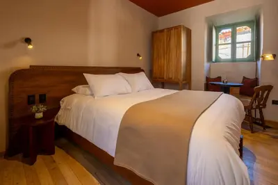 a bedroom with a large bed with white sheets at Hotel 1821 in Cusco