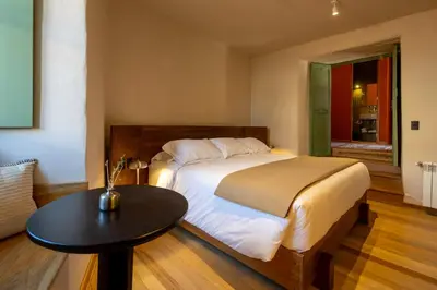 a bedroom with a large bed and a table at Hotel 1821 in Cusco