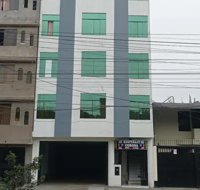 a building with green windows and a garage at Hs Corona in Lima