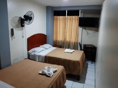 a hotel room with two beds with towels on them at Hs Corona in Lima