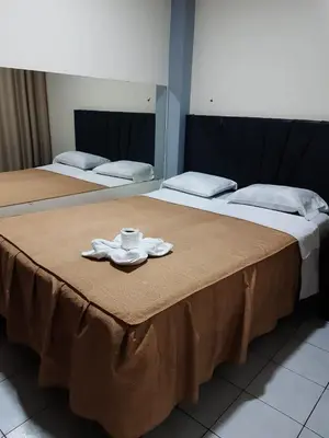 two beds with a napkin and a cup on a table at Hs Corona in Lima