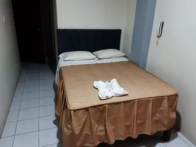 a bed with two white towels on top of it at Hs Corona in Lima