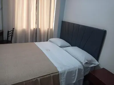 a bedroom with a large bed with white sheets and pillows at Hs Corona in Lima