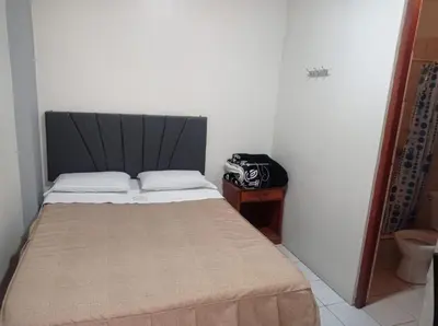 a small bedroom with a bed with a black headboard at Hs Corona in Lima