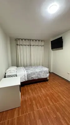 a bedroom with a bed and a flat screen tv at Habitación privada a 20 min del Aeropuerto de LIMA in Lima