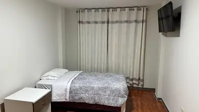 a small bedroom with a bed and a window at Habitación privada a 20 min del Aeropuerto de LIMA in Lima
