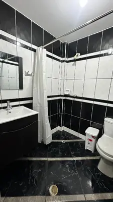 a black and white bathroom with a toilet and a sink at Habitación privada a 20 min del Aeropuerto de LIMA in Lima